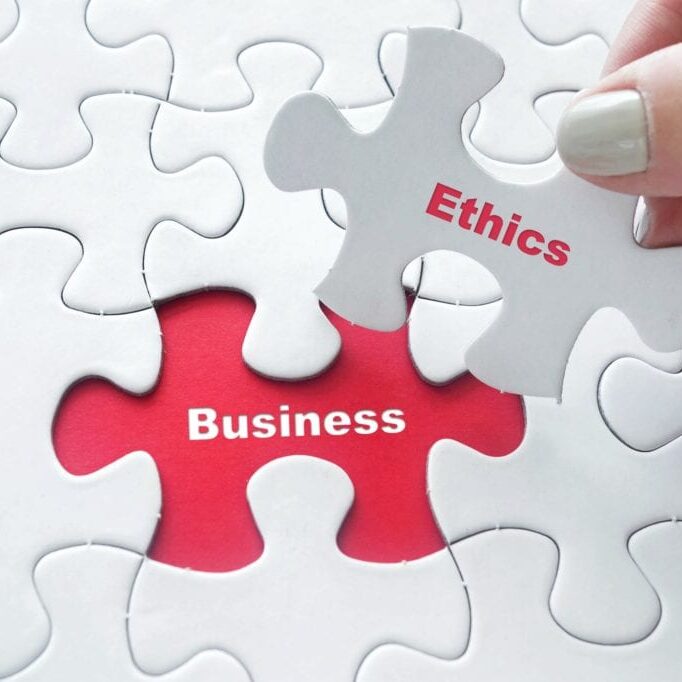 AdobeStock_134423901-sm Close up of girl's hand placing the last jigsaw puzzle piece with word Business Ethics